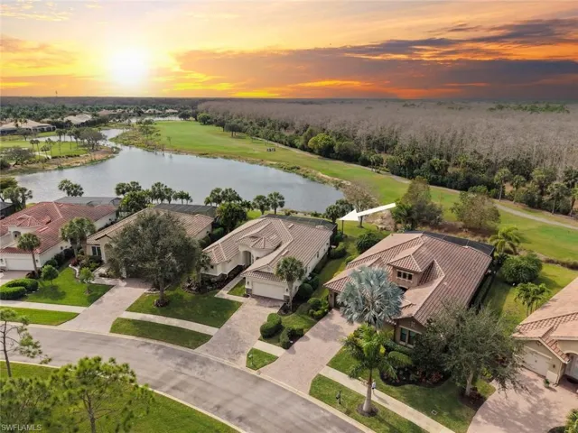 Aerial view at dusk of a water view, a residential view, and golf course view