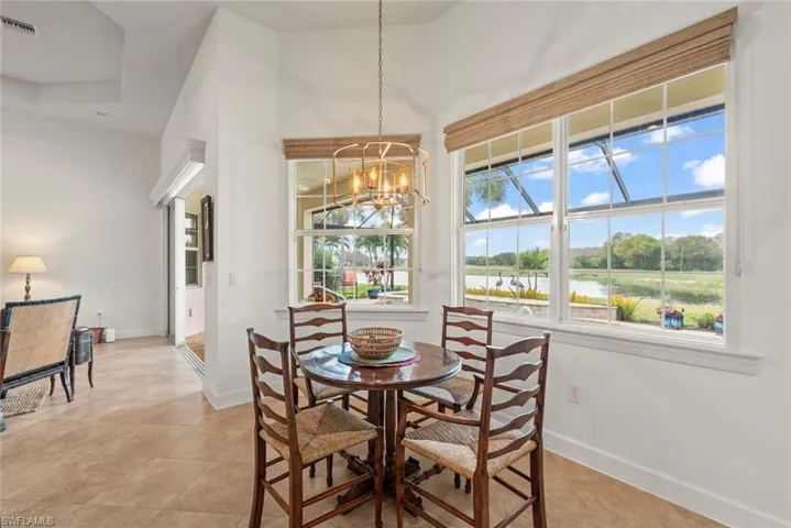 Dining area with a chandelier, a water view, and light tile patterned floors