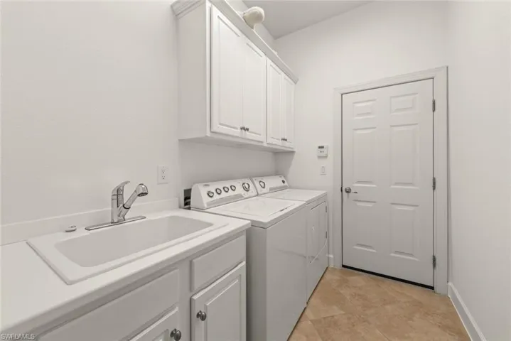 Washroom featuring cabinet space and washer and clothes dryer