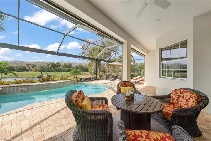 Swimming pool featuring screened-in lanai with picture screen, covered lanai area with shades and lounge area