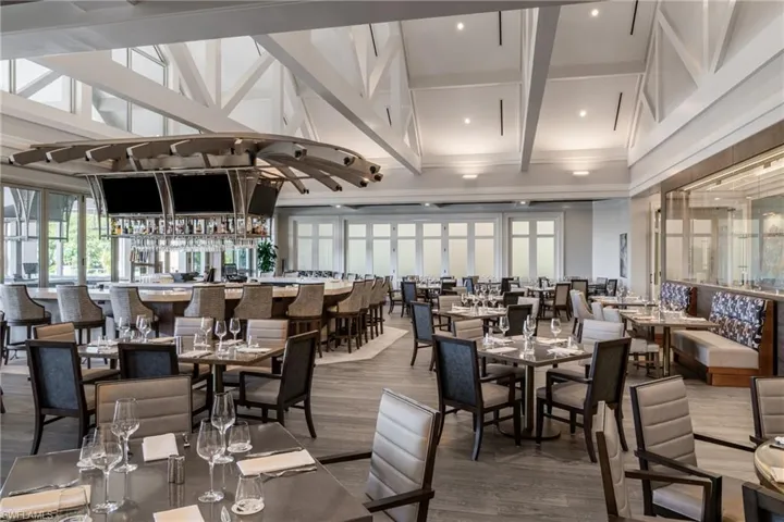 Twin Eagles indoor Dining area featuring beamed ceiling, wood finished floors, a high ceiling, and coffered ceiling