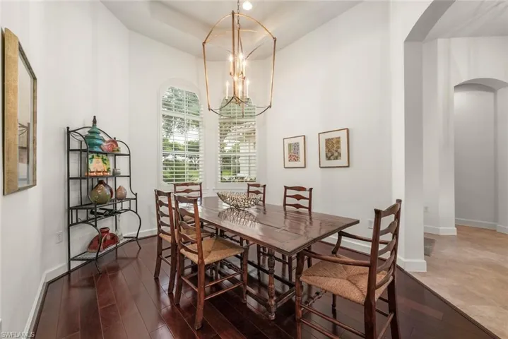 Dining area featuring a high ceiling, dark wood-style floors, and a chandelier