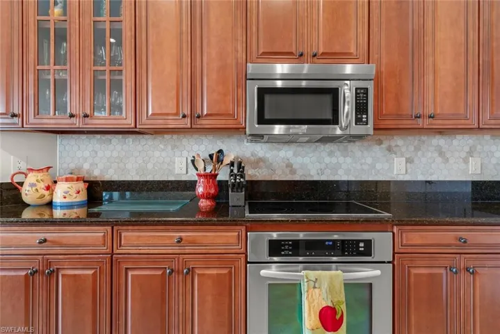Kitchen featuring stainless steel appliances, granite counters, ample cabinets, and new decorative backsplash