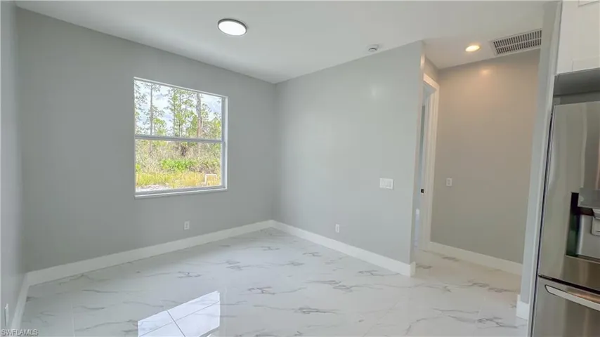 Spare room with marble finish floor, baseboards, visible vents, and recessed lighting