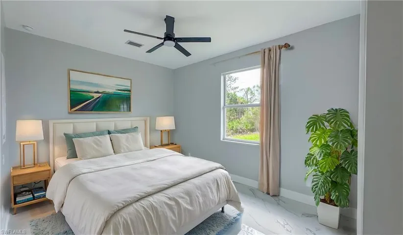 Bedroom with marble finish floor, baseboards, visible vents, and a ceiling fan