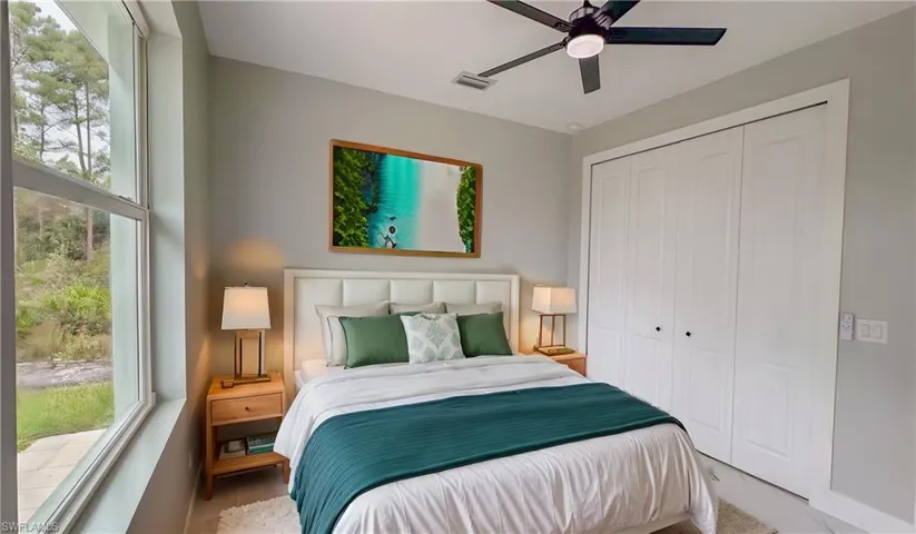 Bedroom with multiple windows, visible vents, a closet, and a ceiling fan