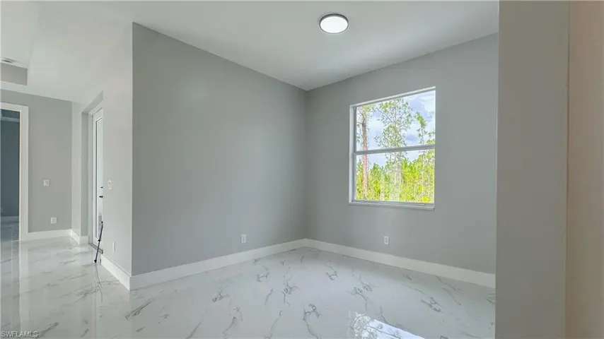 Spare room featuring marble finish floor and baseboards