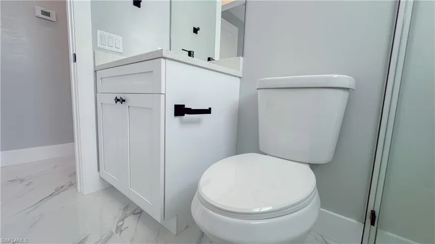 Bathroom featuring marble finish floor and toilet