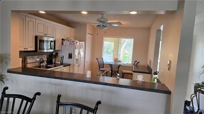 View of kitchen from dining room featuring recessed lighting, extra bank of cabinets and pantry