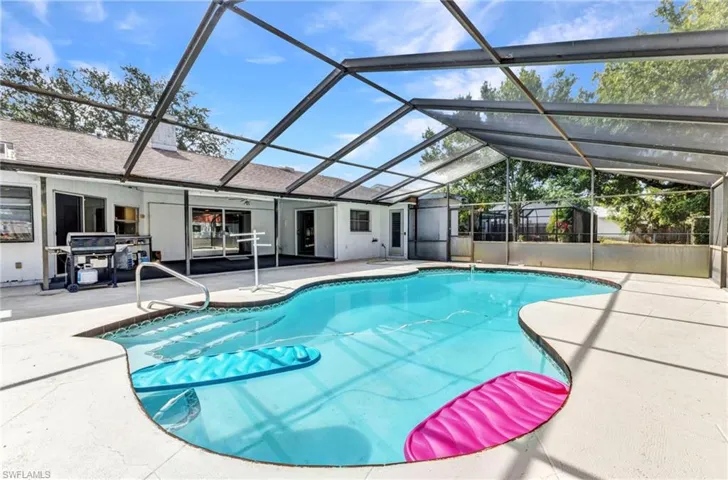 Swimming pool featuring a patio area, a grill, and a lanai