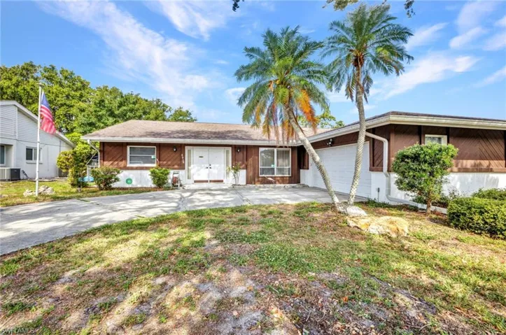 Single story home with driveway, an attached garage, and cooling unit