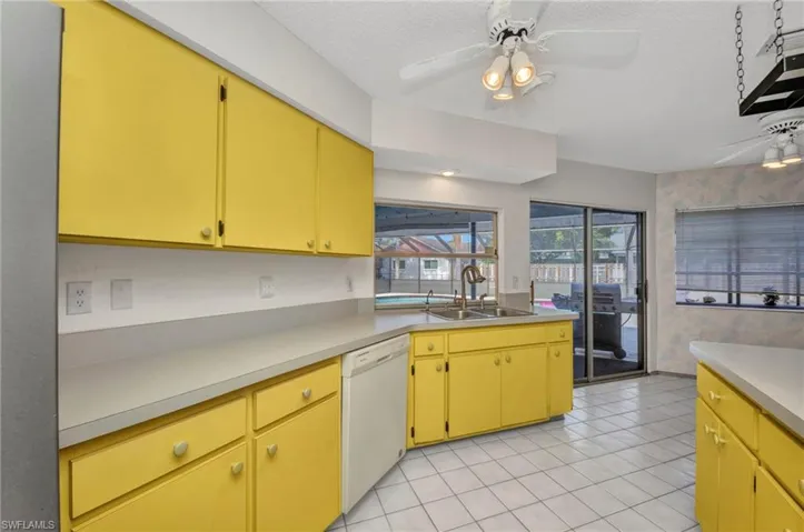 Kitchen with a sink, dishwasher, ceiling fan, a textured ceiling, and light countertops