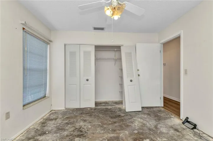 Unfurnished bedroom featuring a closet, a textured ceiling, a ceiling fan, and baseboards