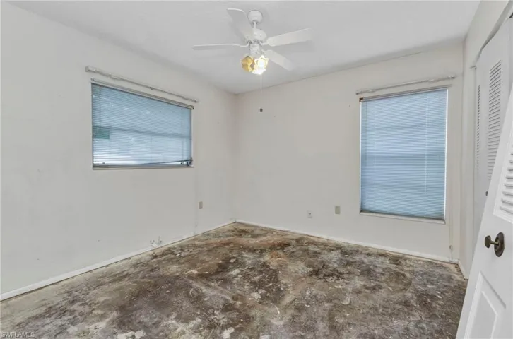 Unfurnished room with ceiling fan and baseboards