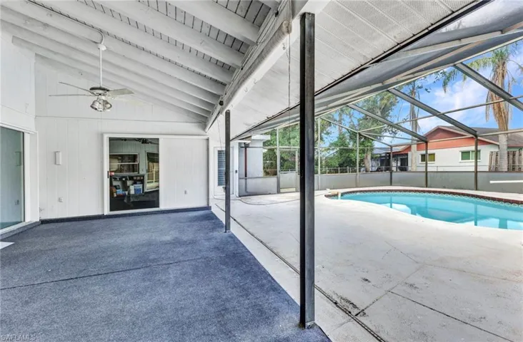 View of pool featuring a ceiling fan, a patio, and glass enclosure