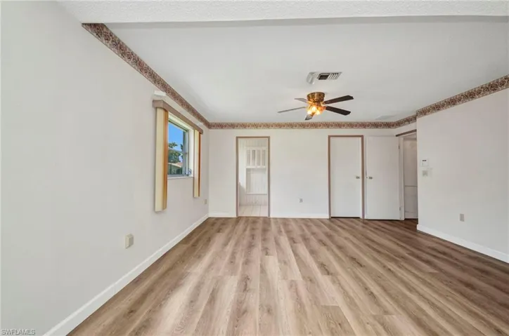 Unfurnished bedroom with light wood finished floors, baseboards, and ceiling fan