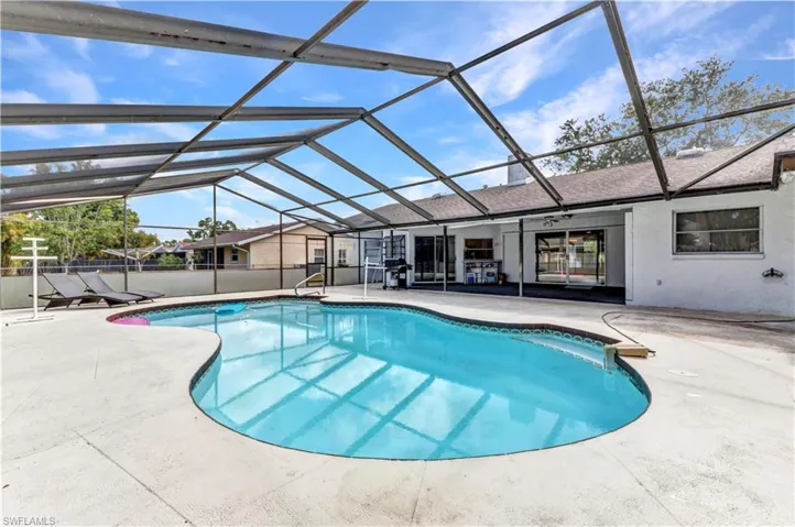 View of pool featuring a patio and glass enclosure