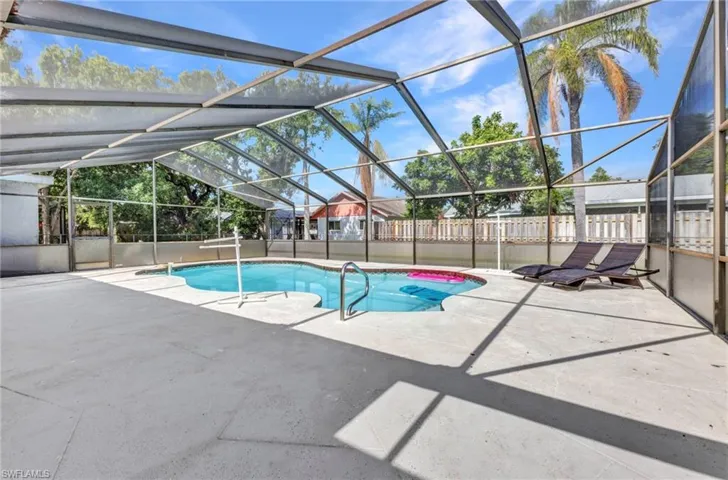 View of pool featuring a patio area, a fenced backyard, and a lanai