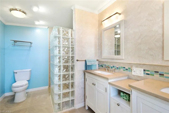 Full bathroom with vanity, ornamental molding, a walk in shower, light tile patterned flooring, and wallpapered walls