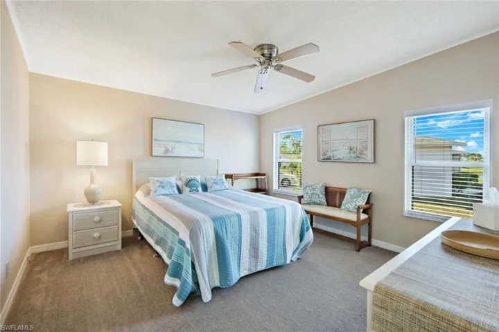 Carpeted bedroom with lofted ceiling, a ceiling fan, a textured ceiling, and crown molding