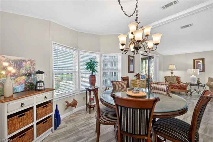 Dining area featuring ornamental molding, a chandelier, and a textured ceiling