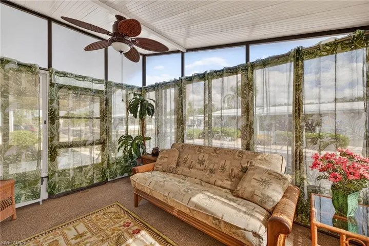 Sunroom featuring expansive windows and carpet