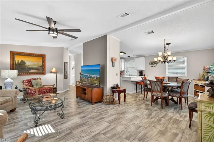 Living room featuring a chandelier, ceiling fan, and a textured ceiling