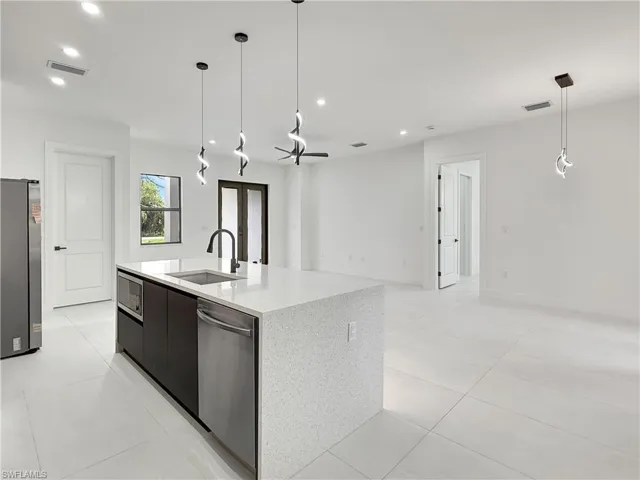 Kitchen with a sink, stainless steel appliances, recessed lighting, modern cabinets, and pendant lighting