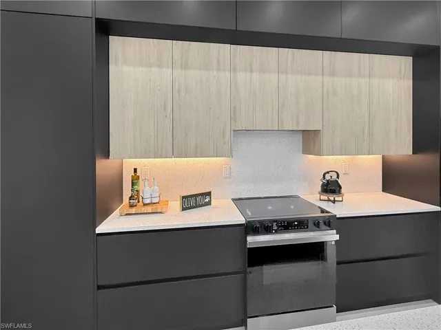 Kitchen with electric range oven, modern cabinets, light countertops, and light brown cabinetry