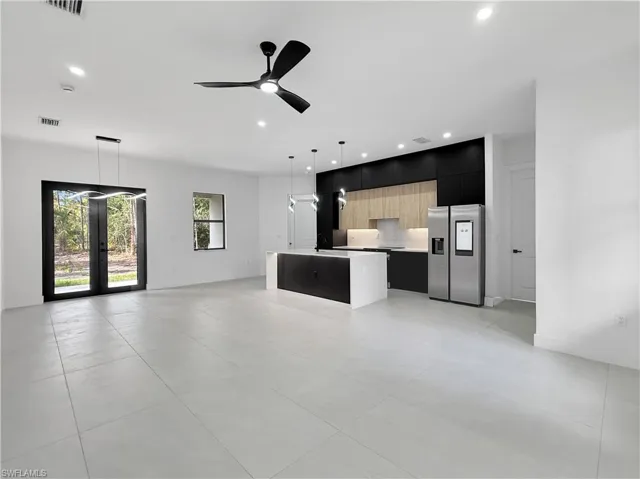 Unfurnished living room featuring recessed lighting, a ceiling fan, french doors, light tile patterned floors, and a sink