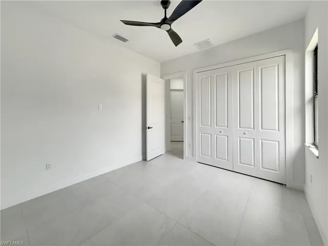 Unfurnished bedroom with a closet, baseboards, and a ceiling fan
