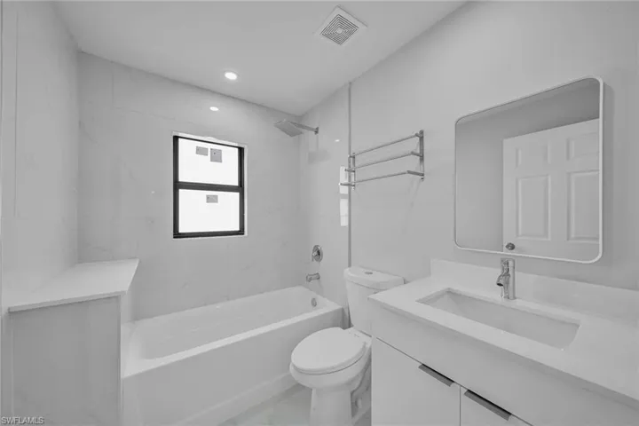 Full bath featuring vanity, tub / shower combination, recessed lighting, and marble finish floors