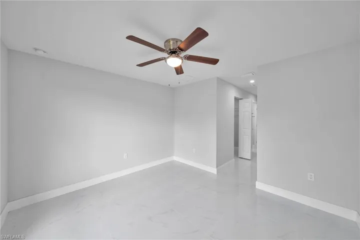 Empty room with a ceiling fan, light marble finish flooring, a smoke detector, and recessed lighting