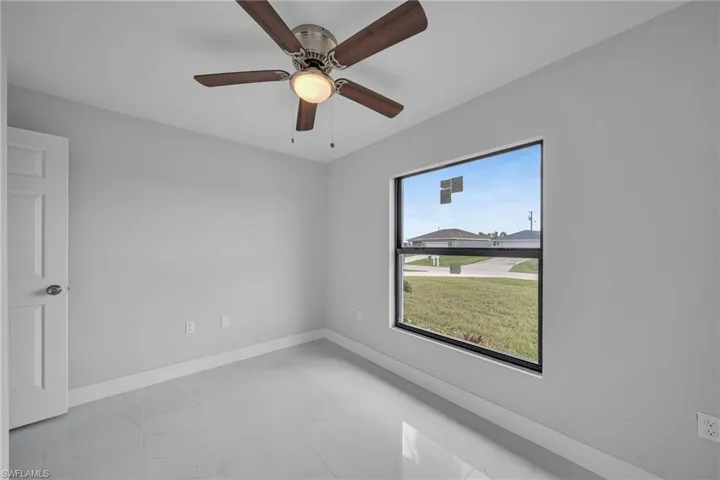 Spare room featuring marble finish floors and ceiling fan
