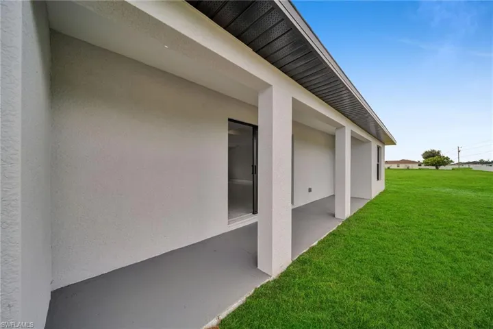 View of grassy yard featuring a patio