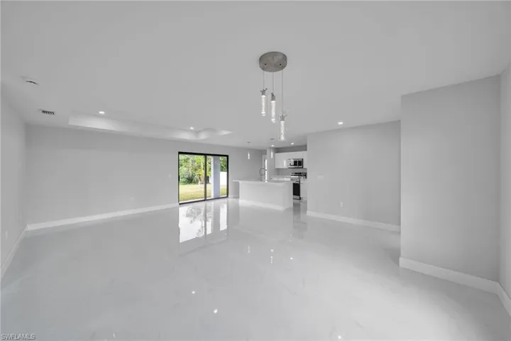 Unfurnished living room with light marble finish flooring and recessed lighting