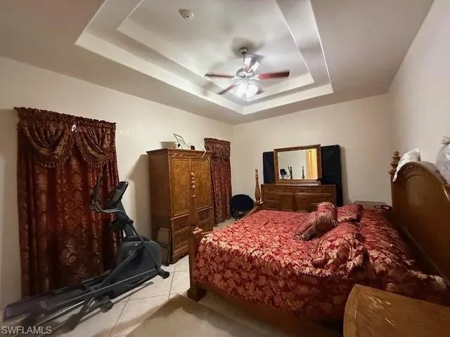 Bedroom featuring a raised ceiling and ceiling fan