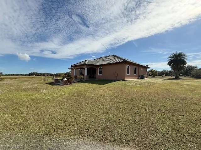 View of property exterior featuring a lawn
