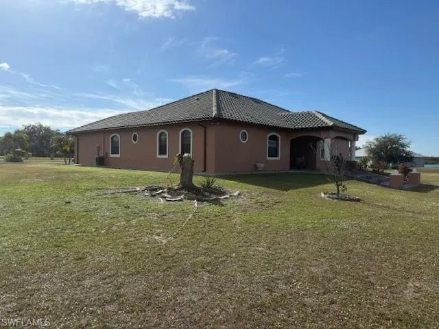View of side of property featuring a lawn