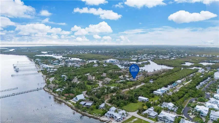 Aerial view of property's location with a nearby body of water and nearby suburban area