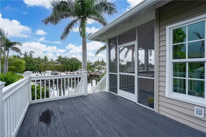 Wooden terrace featuring a water view and a sunroom