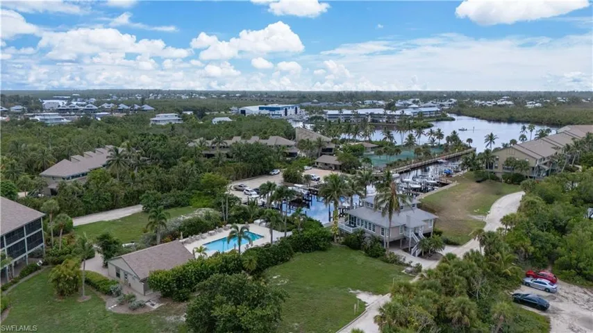 Drone / aerial view of a nearby body of water and a pool area