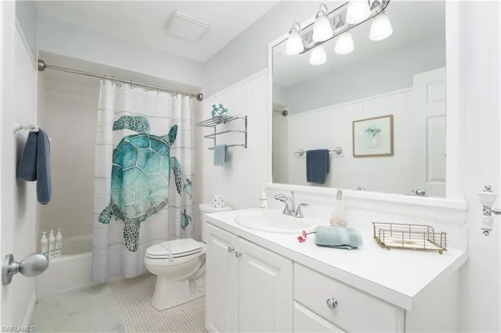 Bathroom featuring shower / bath combo, vanity, and light tile patterned flooring