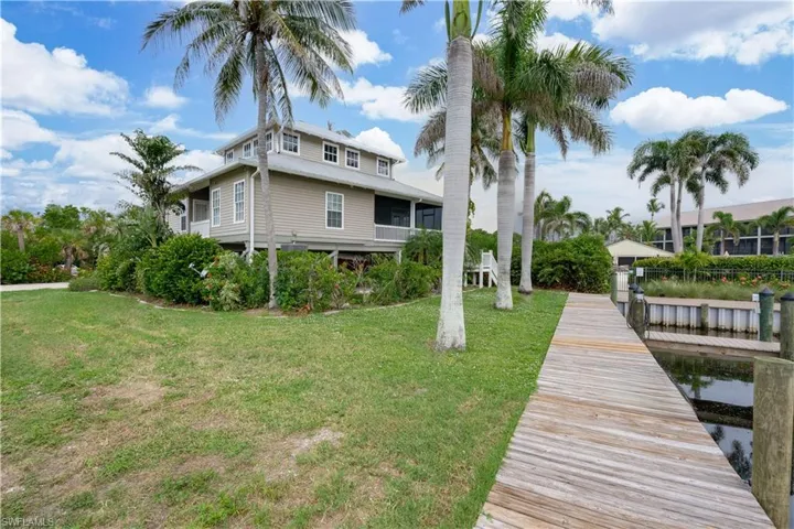 Rear view of house with a yard and a balcony