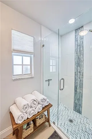 Master Bathroom with a tiled shower stall and window