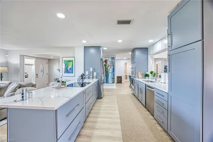 Kitchen featuring stainless steel appliances, open floor plan, and a peninsula