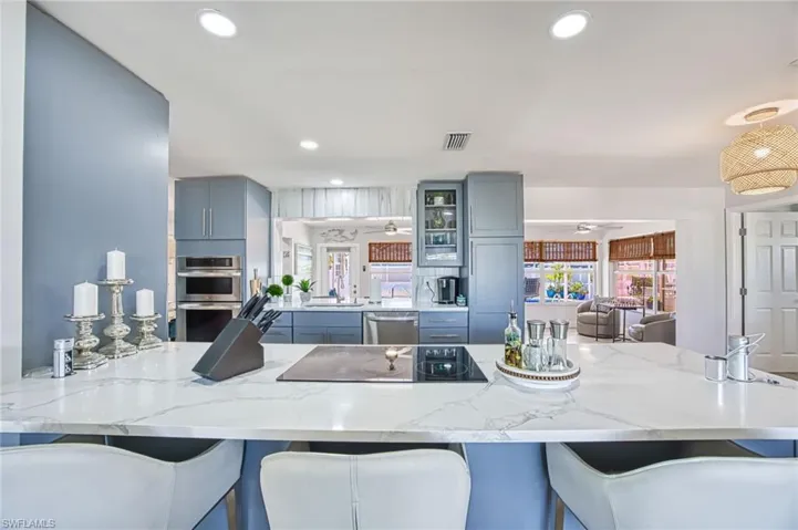 Kitchen featuring granite countertops, a breakfast bar area, recessed lighting, and appliances with stainless steel finishes
