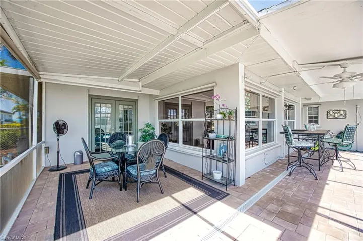 Sunroom / solarium featuring outdoor dining space, beam ceiling, french doors, and ceiling fan