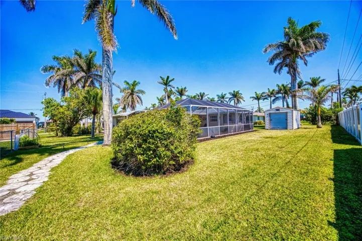 View of yard featuring a storage shed with electric, a Lanai, and fenced in yard