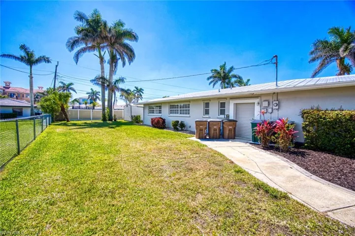 View of yard with a fenced backyard and roll up side door to garage